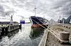 Bygningen er taget på havnen i Nakskov og viser et fragtskib med en stor samling sten på kajkanten.
